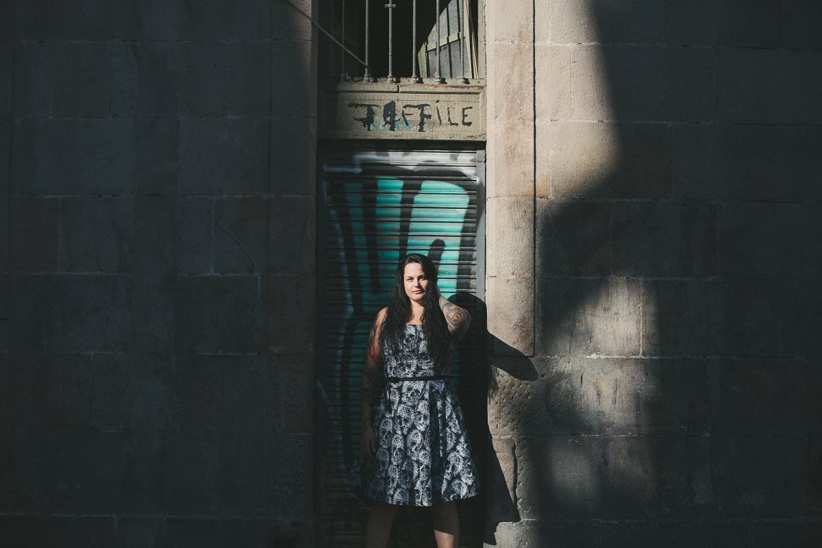 Portrait photography of woman standing in spill of light in Barcelona Gothic Quarter